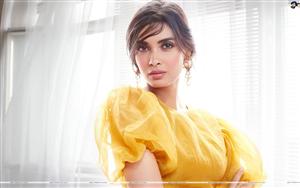 Diana Penty poses graciously in a yellow outfit